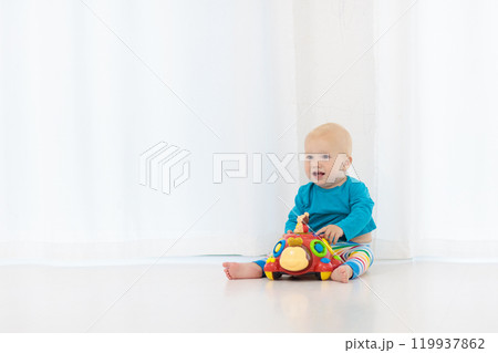 Baby boy playing with toy Baby boy playing with toy 119937862