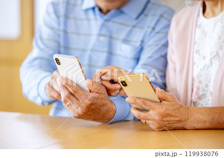 スマホを見るシニア夫婦 スマホを見るシニア夫婦 119938076