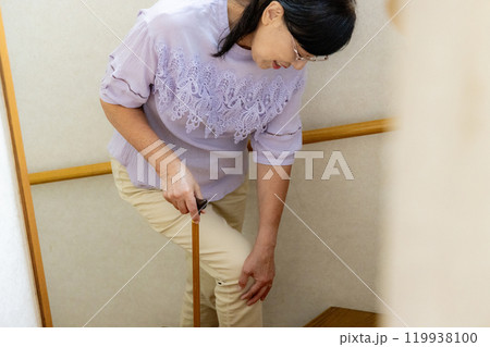 膝が痛いシニア女性　階段 119938100