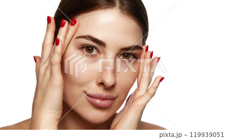 Woman pressing her face with her hands, emphasizing facial wellness and relaxation in beauty practices against white background. Woman pressing her face with her hands, emphasizing facial wellness and relaxation in beauty practices against white background. 119939051