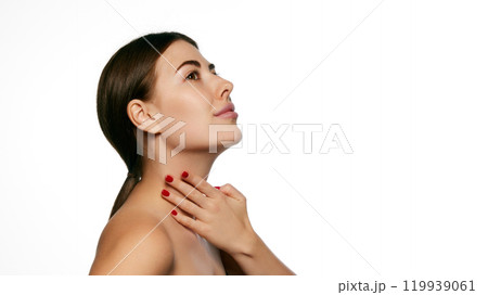 Side profile of woman, with serene expression, gently touching her neck, displaying self-care and skin appreciation against white background. Side profile of woman, with serene expression, gently touching her neck, displaying self-care and skin appreciation against white background. 119939061