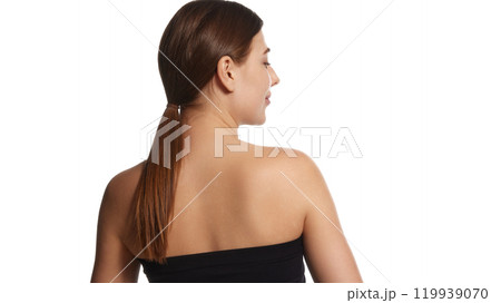Rear view photo of female model in black top posing demonstrate her posture and healthy back against white background. Rear view photo of female model in black top posing demonstrate her posture and healthy back against white background. 119939070