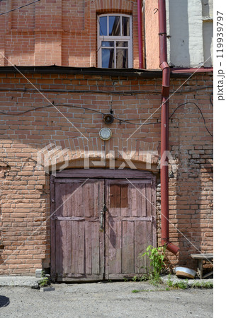 An old peeling wooden gate in a 19th-century brick building in Kuibyshev, Russia An old peeling wooden gate in a 19th-century brick building in Kuibyshev, Russia 119939797