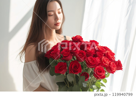 A beautiful bouquet of pastel red roses in female hands. Work as a florist in a flower shop. Delivery of fresh cut flowers. European flower shop. Beautiful girl holding a bouquet of red roses A beautiful bouquet of pastel red roses in female hands. Work as a florist in a flower shop. Delivery of fresh cut flowers. European flower shop. Beautiful girl holding a bouquet of red roses 119940799