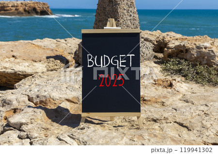 Planning budget 2025 new year symbol. Concept words Budget 2025 on beautiful yellow chalk blackboard. Beautiful stone beach blue sky sea background. Business budget 2025 new year concept. Copy space. Planning budget 2025 new year symbol. Concept words Budget 2025 on beautiful yellow chalk blackboard. Beautiful stone beach blue sky sea background. Business budget 2025 new year concept. Copy space. 119941302