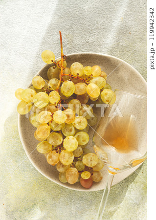 a branch of white grapes, on a gray plate, with a glass of white wine, top view, natural light, food concept, no people, a branch of white grapes, on a gray plate, with a glass of white wine, top view, natural light, food concept, no people, 119942342
