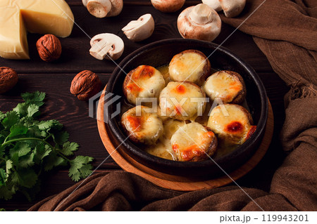 Traditional Georgian dish, appetizer, stuffed mushrooms, Sulguni cheese, baked in a Ketzi clay pan, on a wooden table, close-up, no people, 119943201