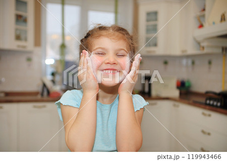 a young girl joyfully covered in flour while cooking in the kitchen. Her beaming smile and playful demeanor reflect the fun and creativity of baking. childhood exploration and the simple joys that 119943466