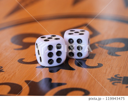 Two dice sit on an ornate wooden board, showing double six combination Two dice sit on an ornate wooden board, showing double six combination 119943475