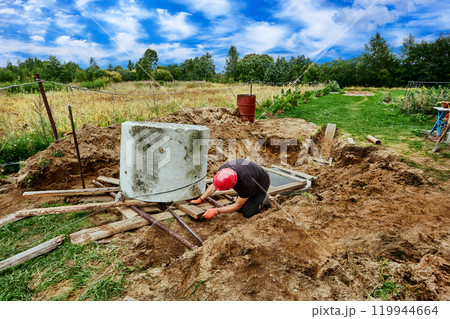 Rigging work to move concrete ring during septic tank installation. Rigging work to move concrete ring during septic tank installation. 119944664