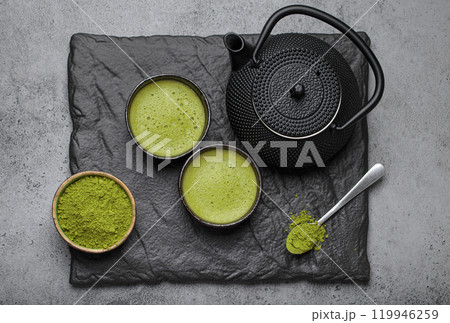 Matcha tea ceremony set with black iron teapot and two cups on black slate plate, traditional Japanese tea top view Matcha tea ceremony set with black iron teapot and two cups on black slate plate, traditional Japanese tea top view 119946259