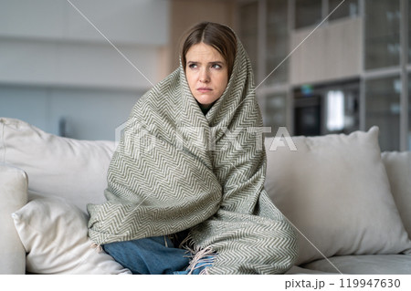 Lonely woman wrapped in blanket sit on couch, feel depression, sadness, emotional burnout, illness 119947630