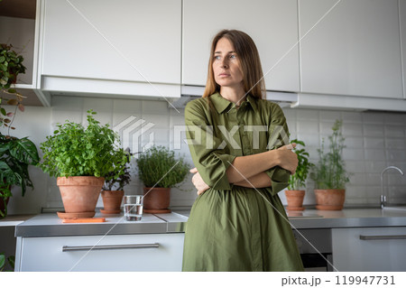 Tired worried woman have bad mood feel solitude with failure standing at home sadly look at window. Tired worried woman have bad mood feel solitude with failure standing at home sadly look at window. 119947731