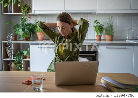 Overworked woman freelancer sitting at table with eyes closed, resting after long hard job on laptop 119947780