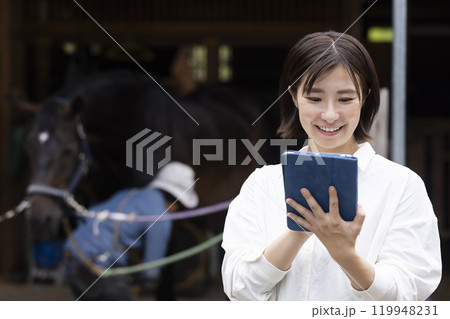 馬のお世話をする女性 119948231