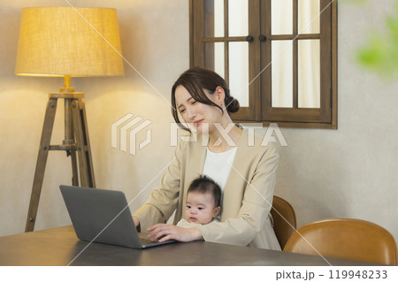 赤ちゃんを抱っこして仕事するスーツを着た女性 119948233