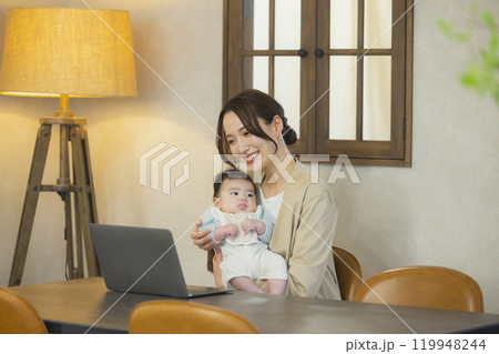 赤ちゃんを抱っこして仕事するスーツを着た女性 119948244
