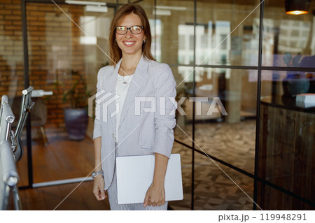 A Confident Business Woman Thrives in a Stylish and Modern Office Environment, Radiating Success 119948291