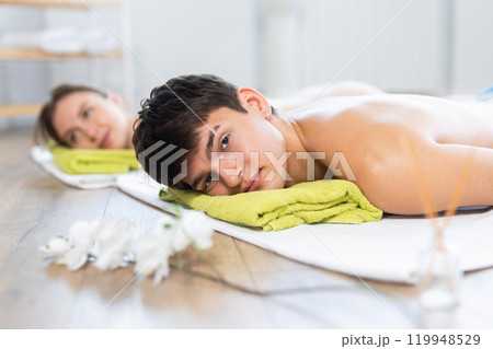Relaxed young man lying on the floor during aromatherapy procedure Relaxed young man lying on the floor during aromatherapy procedure 119948529