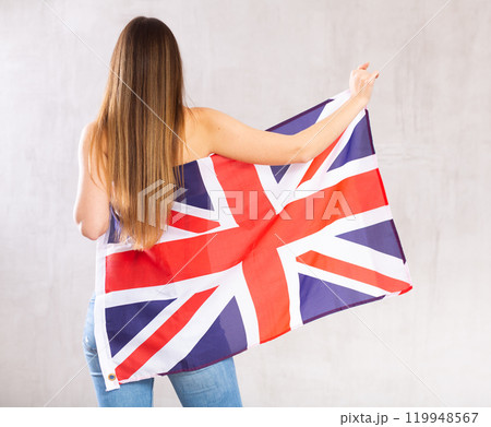 Rear view of semi-nude woman holding flag of Great Britain 119948567