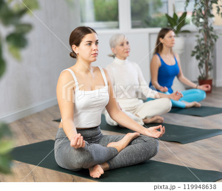 Young woman doing yoga in fitness studio Young woman doing yoga in fitness studio 119948638