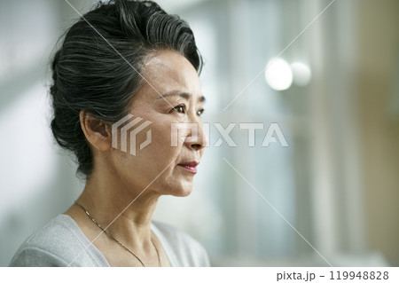 head shot portrait of a sad asian senior woman 119948828
