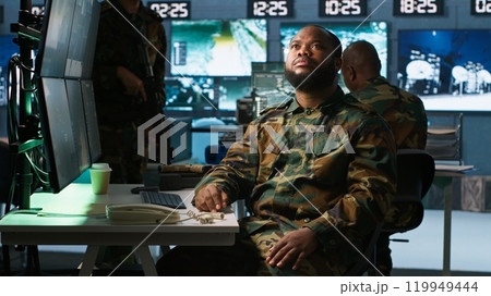 Military officer using augmented reality tracking tech to gain info helpful against enemies. Army expert using AR hologram to gain intel helping troops, coordinating mission activities, camera A 119949444