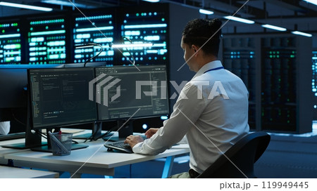 Engineer in data center installing software on computer, troubleshooting issues, handheld camera shot. IT professional in server hub establishing performance benchmarks, camera A 119949445