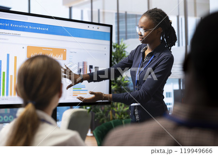 Diverse management team evaluates budget reports on interactive board, discussing strategic investments and plans for the next project objectives in a collaborative boardroom meeting. 119949666