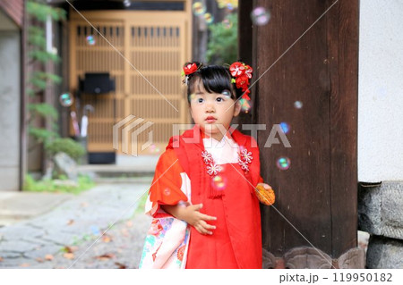七五三詣で可愛い三歳の女の子、神社仏閣での和装ロケーション撮影、被布キッズフォト家族写真 119950182