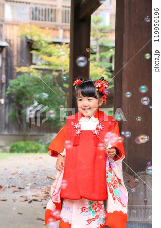 七五三詣で可愛い三歳の女の子、神社仏閣での和装ロケーション撮影、被布キッズフォト家族写真 119950196