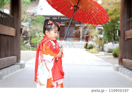七五三詣で可愛い三歳の女の子、神社仏閣での和装ロケーション撮影、被布キッズフォト家族写真 119950197