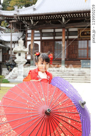 七五三詣で可愛い三歳の女の子、神社仏閣での和装ロケーション撮影、被布キッズフォト家族写真 119950259