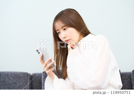 私服の若い女性　リビング　スマホ 119950751