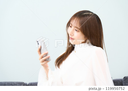 私服の若い女性 リビング スマホ 私服の若い女性 リビング スマホ 119950752