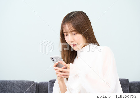 私服の若い女性　リビング　スマホ 119950755