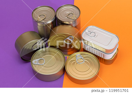 A Group of Stacked Tin Cans with Blank Edges on Split Orange and Violet Background A Group of Stacked Tin Cans with Blank Edges on Split Orange and Violet Background 119951701