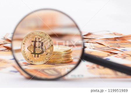 A Stack of Bitcoin Coins Visible Through a Magnifying Glass on the 50-Euro Banknotes A Stack of Bitcoin Coins Visible Through a Magnifying Glass on the 50-Euro Banknotes 119951989