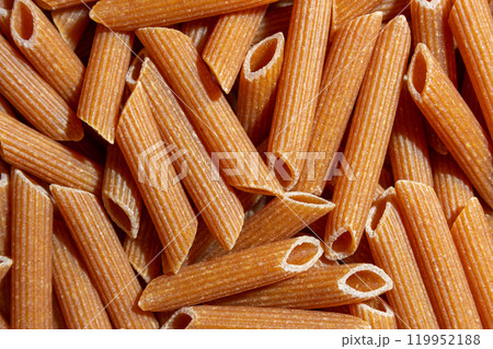 Uncooked Whole Grain Penne Rigate Pasta Background 119952188