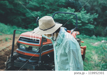 トラクターの点検をする女性 119952301