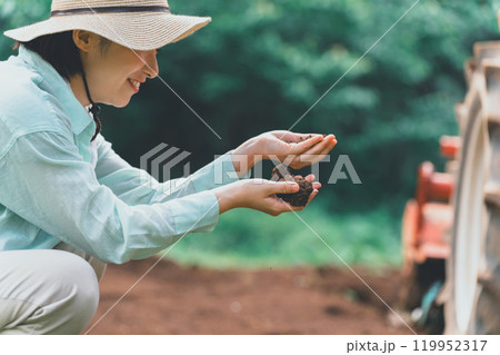 畑の土を見る女性 119952317