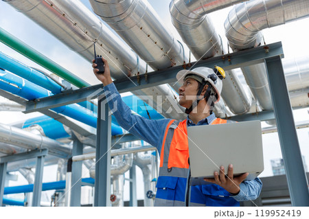 Man Industrial engineer with walkie talkie pointing work at rooftop construction. Male technician working checking HVAC system building factory. Installing large air conditioning system. 119952419
