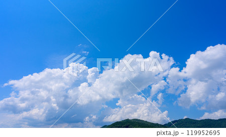 夏の青空のもと、山頂に流れるたくさんの白い雲 119952695
