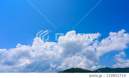 夏の青空のもと、山頂に流れるたくさんの白い雲 119952714