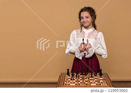Young girl holding chess pieces, black and white 119953002