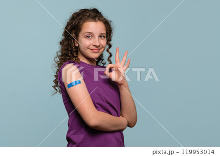 Girl making "OK" gesture with bandage on vaccinated arm Girl making "OK" gesture with bandage on vaccinated arm 119953014