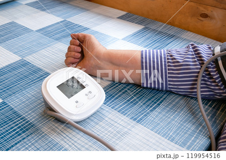 Woman measuring blood pressure. Tonometer and hand on table. Hypertension Woman measuring blood pressure. Tonometer and hand on table. Hypertension 119954516