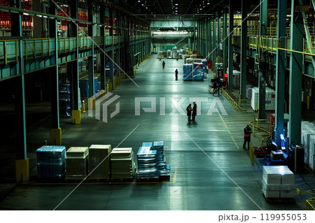 Blurred defocused view of a huge warehouse with neatly lined shelves filled with cardboard boxes. Organized and systematic storage of products ready for shipment. efficient inventory management 119955053