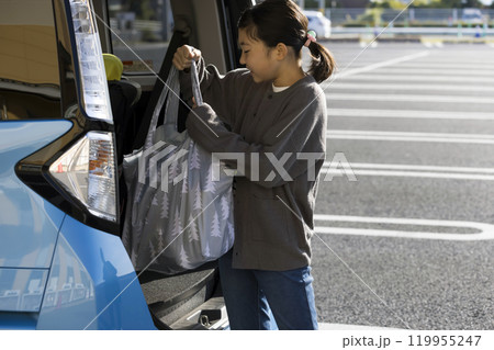 スーパーで買い物をしたマイバッグを車に乗せる小学生女の子 お手伝いイメージ スーパーで買い物をしたマイバッグを車に乗せる小学生女の子 お手伝いイメージ 119955247