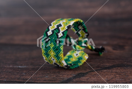 Tied woven friendship bracelets with bright colorful patterns handmade of thread isolated on white background Tied woven friendship bracelets with bright colorful patterns handmade of thread isolated on white background 119955803